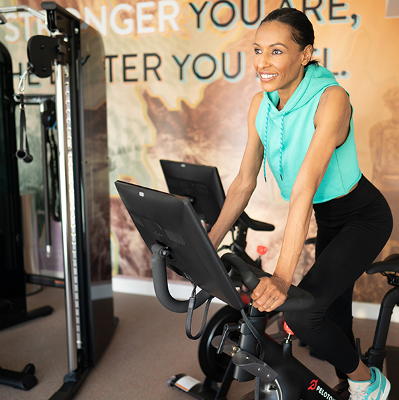 Woman riding Peloton bike in the fitness center at WaterWalk Atlanta