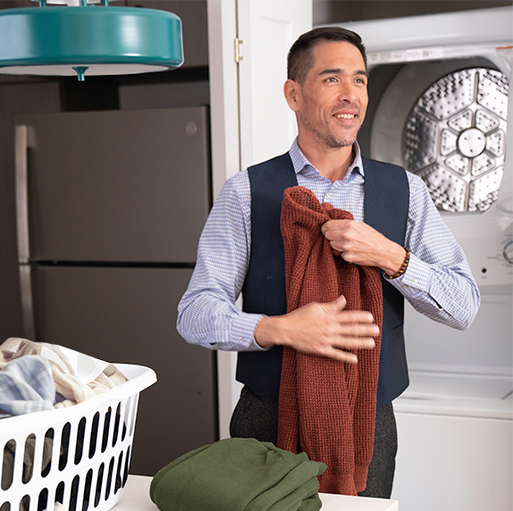 Man folding clothes in Waterwalk apartment